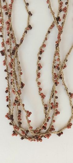 three stranded necklace with red beads and brown glass beads on the end of each strand