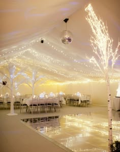 the inside of a tent with tables and chairs set up for a wedding or other function