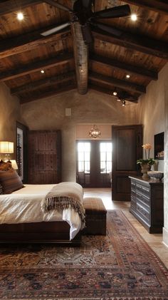 a bedroom with a bed, dressers and ceiling fan in it's center