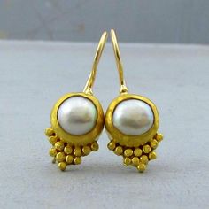 24K Gold Drop Earrings. With the round beige Pearl, each earring is wonderfully balanced with 24k solid gold bezel with hammered 24k solid gold dots decorating each stone. For practicality and elegance, the hooks are handmade locking French wires made of 14k yellow gold with 9k gold backing. ~  Dangle  Earrings Width - 0.4'' ( 10 mm). ~  Length without the ear wire - 0.55" (14 mm). ~  Length from top of the ear wire to bottom of the earring - 1" (26 mm). The earrings will be packed in a gift box ready to give as a gift. The earrings will be shipped via DHL express mail service that usually takes 2-6 days to arrive. Please contact me with any questions or requests. Affordable Yellow Gold Brass Earrings, Yellow Gold Brass Earrings, Cheap Yellow Gold Brass Earrings, 22k Gold Earrings, Handmade Gold Jewellery, Pearls Earrings, 24 Karat Gold, Gold Dangle Earrings, Solid Gold Earrings