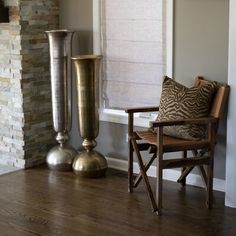 a living room with a chair, vase and fire place