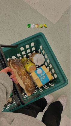 a person holding a shopping basket full of food