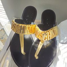 Flat Thong Sandals With Calfskin Upper And Gold Galvanic Lettering Logo. Eur Size 41 Questions? Leave A Comment Below! Luxury Gold T-strap Sandals, Luxury T-strap Sandals For Beach, Designer T-strap Sandals For Summer Beach, Slippers Outfit, Moschino Shoes, Lettering Logo, Thong Sandals, T Strap, Letter Logo