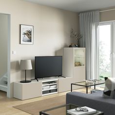 a living room filled with furniture and a flat screen tv on top of a stand