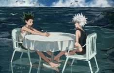 two people sitting at a table in the water