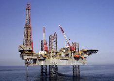 an oil rig in the middle of the ocean with cranes on it's sides