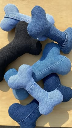 three dog toys are laid out on a wooden surface, one is blue and the other has black bones