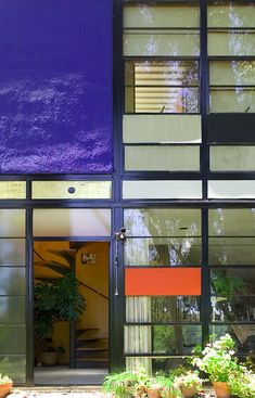 the entrance to an apartment building with plants and potted plants in front of it