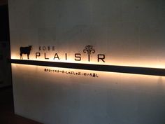 there is a sign on the wall that says plaisir in english and japanese