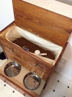 an open wooden box with two bowls inside