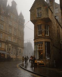 people are walking down the street in the rain