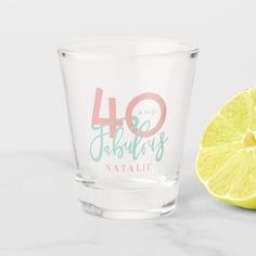 a shot glass with the words 40 and fabulous on it next to a lemon