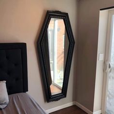 a bedroom with a bed and a large mirror on the wall