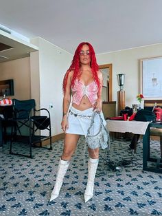 a woman with red hair is posing for the camera in a hotel room wearing white shorts and pink crop top