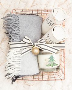 a basket filled with coffee cups and blankets