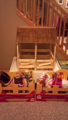 two dolls are sitting in wooden boxes on the floor next to stairs and staircases