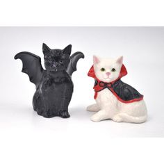 two ceramic figurines of cats dressed up as dracula and cat with bat wings