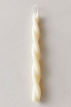 a white candle sitting on top of a table next to a small object that is shaped like a spiral