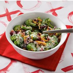 a white bowl filled with broccoli on top of a red napkin