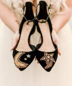 a close up of a pair of black shoes with stars and moon designs on them