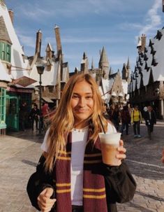 a woman holding a drink in front of hog potter's house