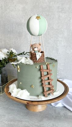 a green cake with a teddy bear on top