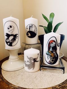 three candles sitting on top of a table next to a potted plant and candle holder