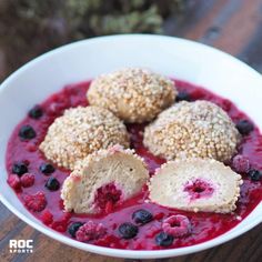 blueberries and raspberry dessert in a white bowl on a wooden table, ready to be eaten