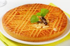 a waffle cake on a white plate with green garnish and some nuts