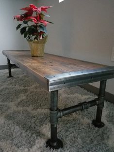 a potted plant sitting on top of a wooden table next to pipe leg legs