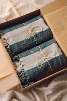 two blue and white striped towels in a box