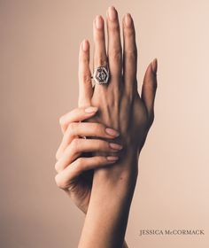 two hands reaching up to each other with a diamond ring on their fingers, both holding the other hand