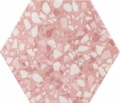 a pink and white hexagonal tile with small rocks on the floor in it