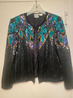 Gorgeous women's 1970's "Stenay" brand beaded jacket size small. The fully lined jacket which closes with hooks & eyes down the front can be worn open or closed! It has approx 18 hooks & eyes, small shoulder pads & is very clean inside & out!  The scoop neck is covered with black sequins with dimensional rich encrusted designs in gold, turquoise, dark purple/navy looking sequins, bugles, small beads & a large matching color bead in the floral center.  It's 100% silk outside & inside. The beading Vintage Blazer For Fall Party, Vintage Fall Blazer For Parties, Vintage Fall Party Blazer, Vintage Costume Outerwear For Spring, Vintage Formal Outerwear With Sequins, Vintage Formal Sequined Outerwear, Vintage Sequined Formal Outerwear, Vintage Outerwear For Night Out In Spring, Embroidered Fitted Outerwear For Party