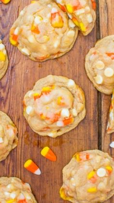 halloween candy cookies on a wooden table with candy corn and carrots scattered around them