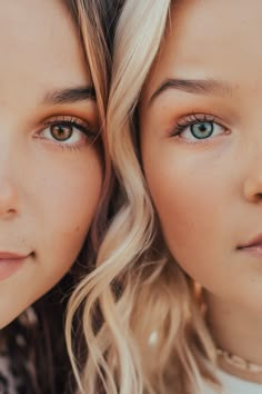 two beautiful young women with blue eyes posing for the camera, both looking at the camera