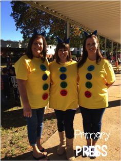 three women in yellow shirts are standing together