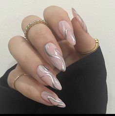 a manicure with white and silver designs on it's nails is seen in this image