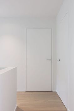 an empty room with white walls and wooden floors