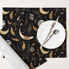 a plate, fork and knife are sitting on a place mat with a black background