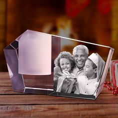 a glass block with an image of two women and a child on it next to a christmas ornament