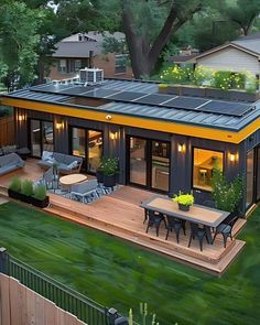 an aerial view of a small house with solar panels on the roof and patio area