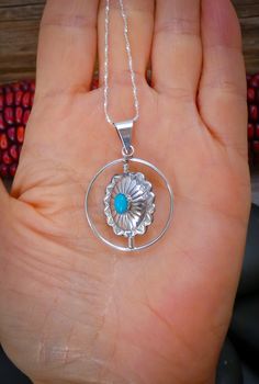 This pendant is handcrafted with Sterling Silver and is set with Turquoise and Coral stones into a concho design. This pendant features a spinner that allows you to turn to the side you want. You can wear it as a Turquoise pendant one day, and a Coral pendant the next. The styling is soft, modern, and lightweight. It'll compliment any outfit that is worn with this. Measures: 1 11/16” x 1 1/8” Includes 20" Silver Chain Vintage never worn Southwestern Concho Necklace As Gift, Southwestern Style Concho Necklace As Gift, Southwestern Style Concho Necklace For Gift, Southwestern Silver Turquoise Necklace With Round Pendant, Silver Southwestern Turquoise Necklace With Round Pendant, Artisan Turquoise Concho Necklace Gift, Southwestern Sterling Silver Turquoise Concho Necklace, Southwestern Style Concho Pendant Jewelry, Sterling Silver Turquoise Necklace With Concho