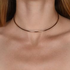 Our 70's inspired Essential Wire Collar has a slim silhouette, and can be layered. Simple and elegant with a variety of necklines. Handcrafted in NYC 14k gold or rose gold finish 12" adjustable collar fits most neck sizes Brass with nickel free electroplating Clear protective finish prevents premature wear and tarnish Comes in a signature pouch with box Remove electroplated jewelry when bathing, showering or swimming. Avoid direct contact with perfume, lotions or other chemicals. Wipe clean with