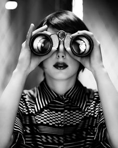 a woman looking through binoculars at the camera