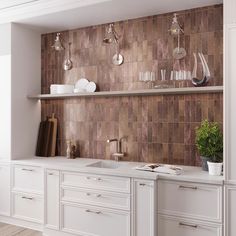 a kitchen with white cabinets and brown tile backsplashing, potted plant on the counter