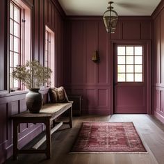 a room with red walls and wooden floors, along with a rug on the floor