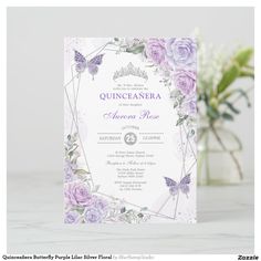 a wedding card with purple roses and butterflies on it, sitting next to a vase filled with flowers