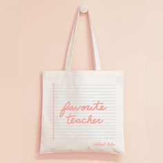 a white tote bag hanging on a pink wall