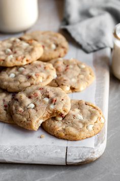 several cookies are on a white tray next to a glass of milk and a napkin